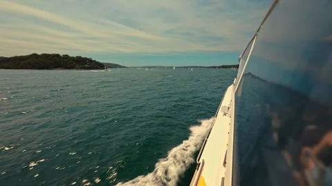 The hull of a high-speed ferry cuts through turquoise harbor waters, with Video stock 315672606