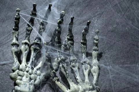 Human arm skeleton covered with spiderwebs. The human skull, devil, evil, o.. Stockfoto's