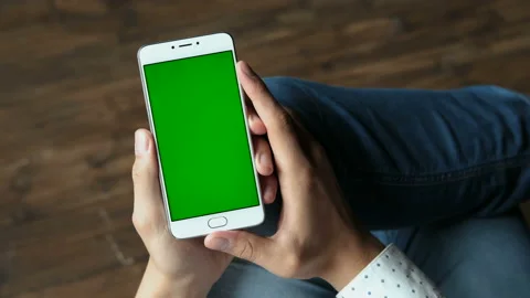 Human arms hold electronics portable device with greenscreen chromakey closeup. Stock Footage 199492751