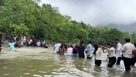 Human chain crossing a river during a trekking adventure in the mountains Vídeo Stock 340251810