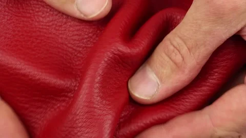 Human check quality and testing red natural soft leather, macro closeup Stockbeeldmateriaal 145536003