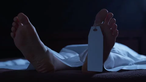 A human corpse lying in a morgue, covered with a white sheet and a tag  Stock Footage 325595483