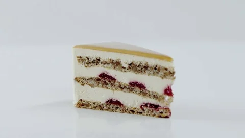 Human decorates the rotating piece of caramel cake with cherry filling Stock Footage 72250488