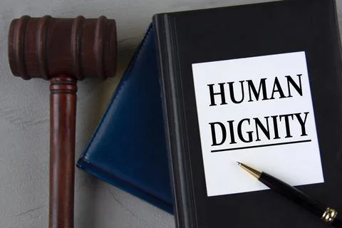 HUMAN DIGNITY - words on a white sheet with leather notebooks, a judge's ha.. Stock Photos