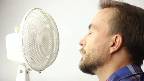 Human face near working old fan ventilator, enjoying coolness, white background Stockbeeldmateriaal 157594486