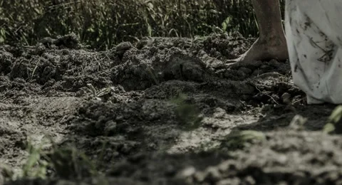 Human feet are on the ground and wet clay. Stock Footage 68636378