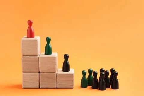 Human figures, red one on top of stacked wooden cubes against orange backgr.. Stock Photos