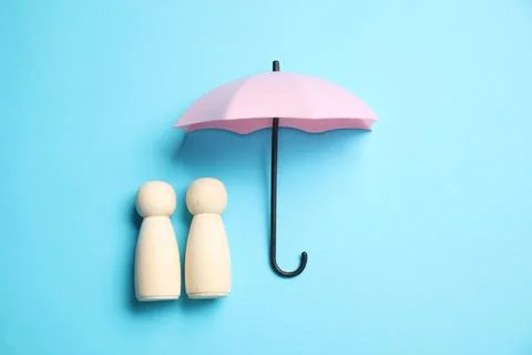 Human figures under umbrella on light blue background, top view. Insurance .. Stock Photos