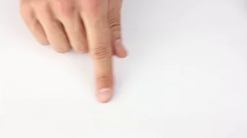 Human finger imitates eraser on white table, wipes invisible symbols Stockbeeldmateriaal 85508885