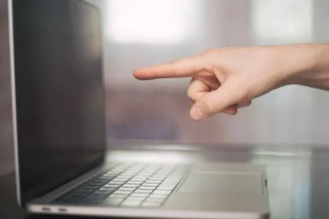 Human finger pointing on the computer screen and blur effects flare side view Stock Photos