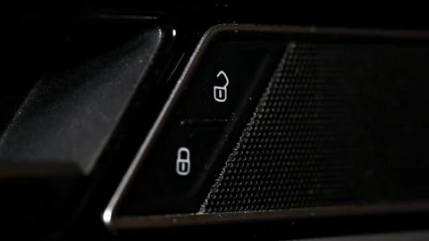 Human finger presses unlock button of car door interior, activating vehicle Stock Footage 325697154