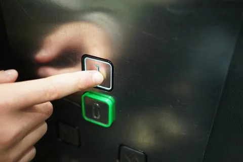 Human finger pressing the first floor button on a modern elevator control p.. Stock Photos