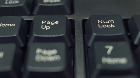 Human finger repeatedly pressing the num lock key on a black keyboard. Video stock 146471182