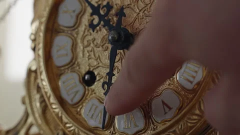 Human finger setting the time on a vintage golden clock Stock Footage 340508852