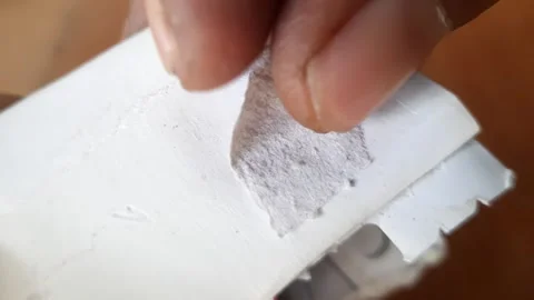 Human fingers peeling off thin paper scraps stuck to another white paper su.. Stock Footage 324825113
