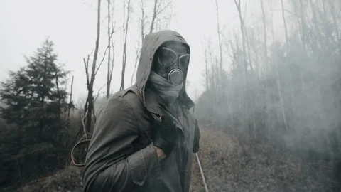 Human in gas mask walking in clouds of toxic smoke, survivor after chemical war Stock Footage 119664555
