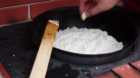 Human hand added cloves of garlic in white rice, preparation of pilaf Video stock 56315859