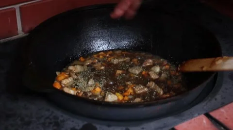 Human hand added spices in the boiling oil with meat and mixing it Stockbeeldmateriaal 56315681