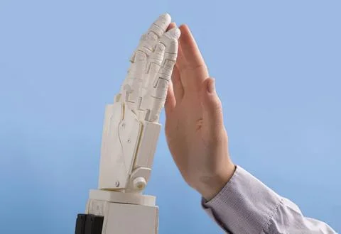 Human hand and robot hand high five in blue background Stock Photos