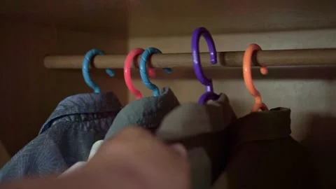 Human hand arranging clothes on hangers in a wardrobe, Stockbeeldmateriaal 339122105