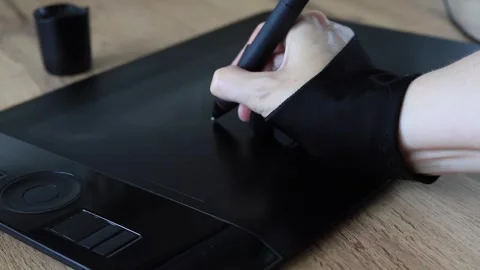 Human hand in a black two-finger glove draws with a stylus Stock Footage 339616617
