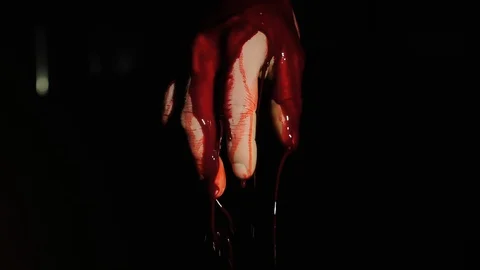 On the human hand, blood flows down against a dark background Stock Footage 105259939