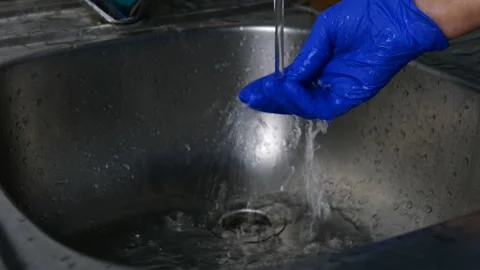 Human hand in blue protective rubber glove washes his hand. Stock Footage 129464177