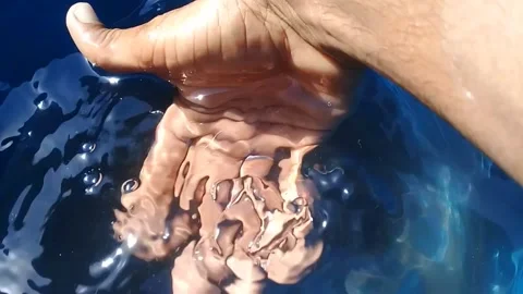  A human hand in blue water Stock Footage 169835752