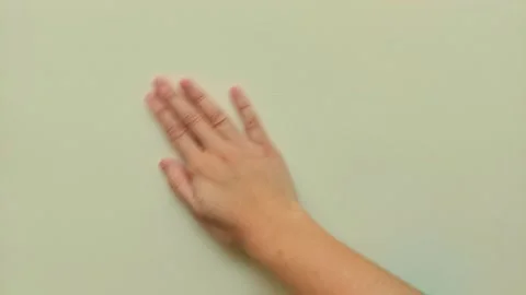 Human Hand Brushing Across Smooth Green Wall Surface Vídeos de archivo 343859361