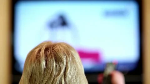 Human hand changes the channels on the television with remote control. Stock Footage 257873628