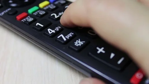Human hand changes the channels on the TV remote control Stock Footage 69767289