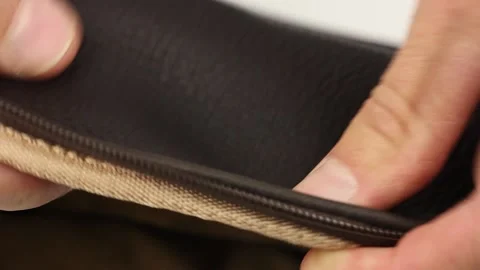 Human hand check quality of brown natural leather with brown zipper Видео 145535778