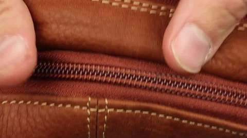 Human hand check quality brown natural smooth matt leather zipper, close-up Video stock 145535788