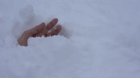 A human hand comes out of the snow after an avalanche. The person stuck in the Stock Footage 155478532
