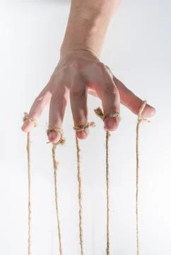 The human hand controls the puppet with the fingers attached to them threads Stock Photos