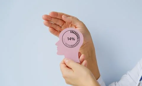 A human hand covers a human head figurine on a blue background, taking care.. Stock Photos