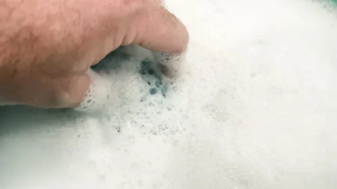 Human hand creating foam with sponge. Preparation of foamy, soapy liquid for  Stock Footage 208836386