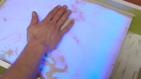 Human hand draws a tree on a light table with sand Stock Footage 106063717