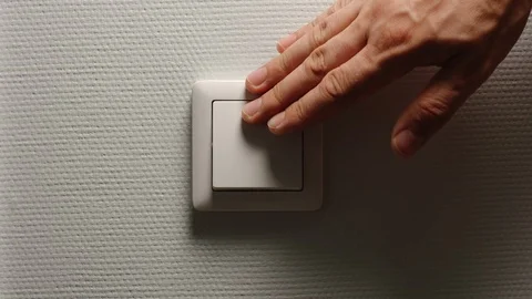 Human hand fast turn off a power button on a light-grey wall - Front view Vídeo Stock 92400828