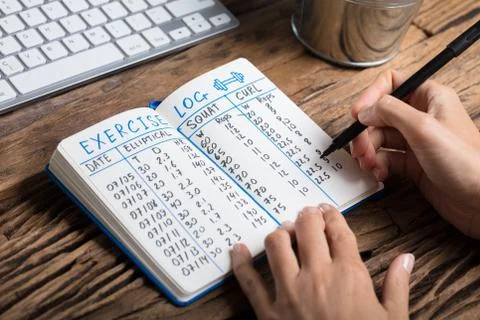 Human Hand Filling Exercise Log On Notebook Foto stock