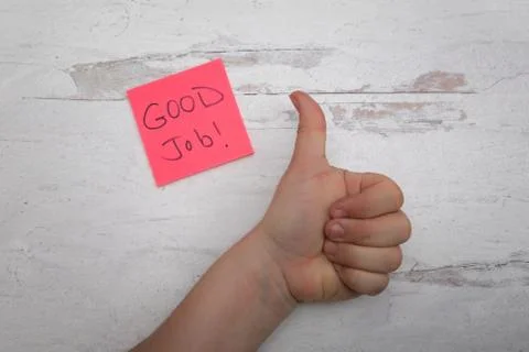 Human hand giving gesturing a approval thumbs up with good job pink posted note Stock Photos