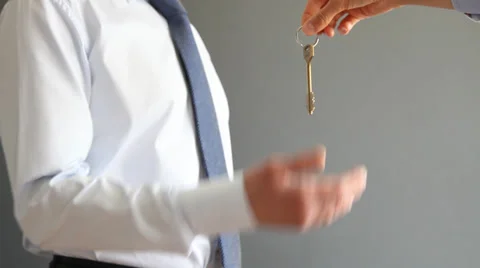 Human hand giving a key to an unrecognizable businessman in a suit Stock Footage 31734790