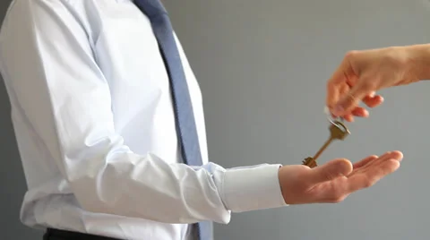 Human hand giving a key to an unrecognizable businessman in a suit Stock Footage 31736218