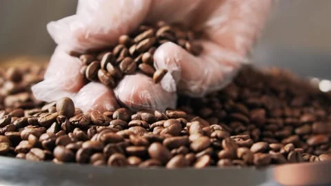 Human hand in glove touching roasting coffee beans. Stock Footage 139631444