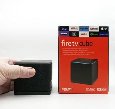 Human hand holding an Amazon Fire TV Cube isolated on a white background. Stock-Fotos