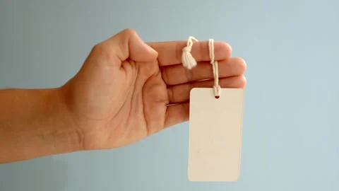 Human hand holding a blank white tag perfect for custom messages branding Stock Footage 341499533