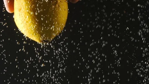Human hand holding fresh lemon under the water on black background. Citrus in 库存影片 111413018