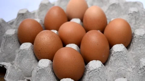 Human hand holding hen eggs in egg tray on white background Stock Footage 132019386