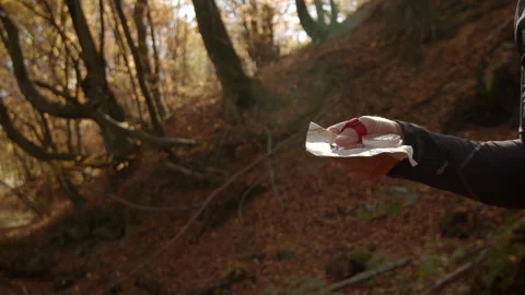 Human hand holding orienteering map and compass in sunny autumn forest. Camera Stock Footage 166154553