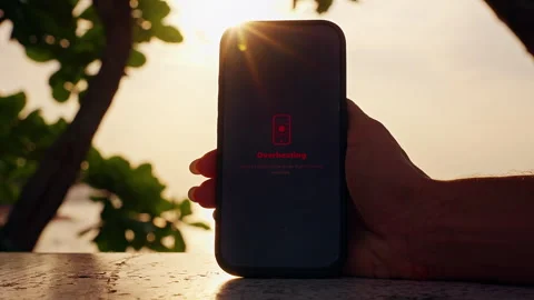 Human Hand Holding Smartphone With Overheating Warning On Screen Under Intense T Stock Footage 330884287